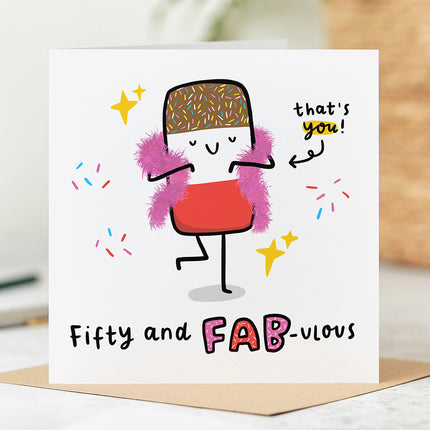 Birthday card with an image of a bright and colourful ice lolly wearing a feather boa. The text on the card reads 'Fifty and Fab-ulous' in bold, playful letters.