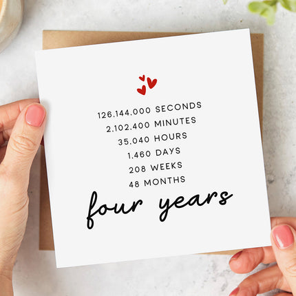 Greeting card with three red hearts followed by the wording '126,144,000 SECONDS 2,102,400 MINUTES 35,040 HOURS 1,460 DAYS 208 WEEKS 48 MONTHS four years'.
