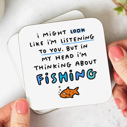 White coater with the text 'I might look like I'm listening to you, but in my head I'm thinking about fishing' followed by a playful fish illustration.