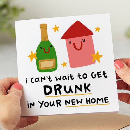 Folded white card with a bottle of alcohol and a home that says 'I can't wait to get drunk in your new home'