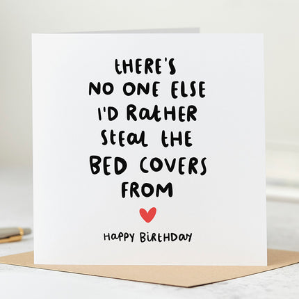 White greeting card with the text 'There's No One Else I'd Rather Steal The Bed Covers From' with a red heart, followed by the text 'Happy Birthday'.