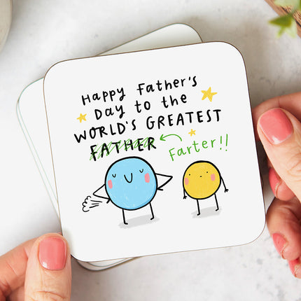 White coaster with text that reads 'Happy Father's Day To The World's Greatest Farter' with the word 'Father' crossed out, followed by a playful illustration of two silly blobs.