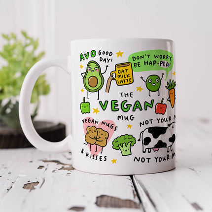A white ceramic mug with colourful illustrations of various plant-based foods and witty vegan puns.